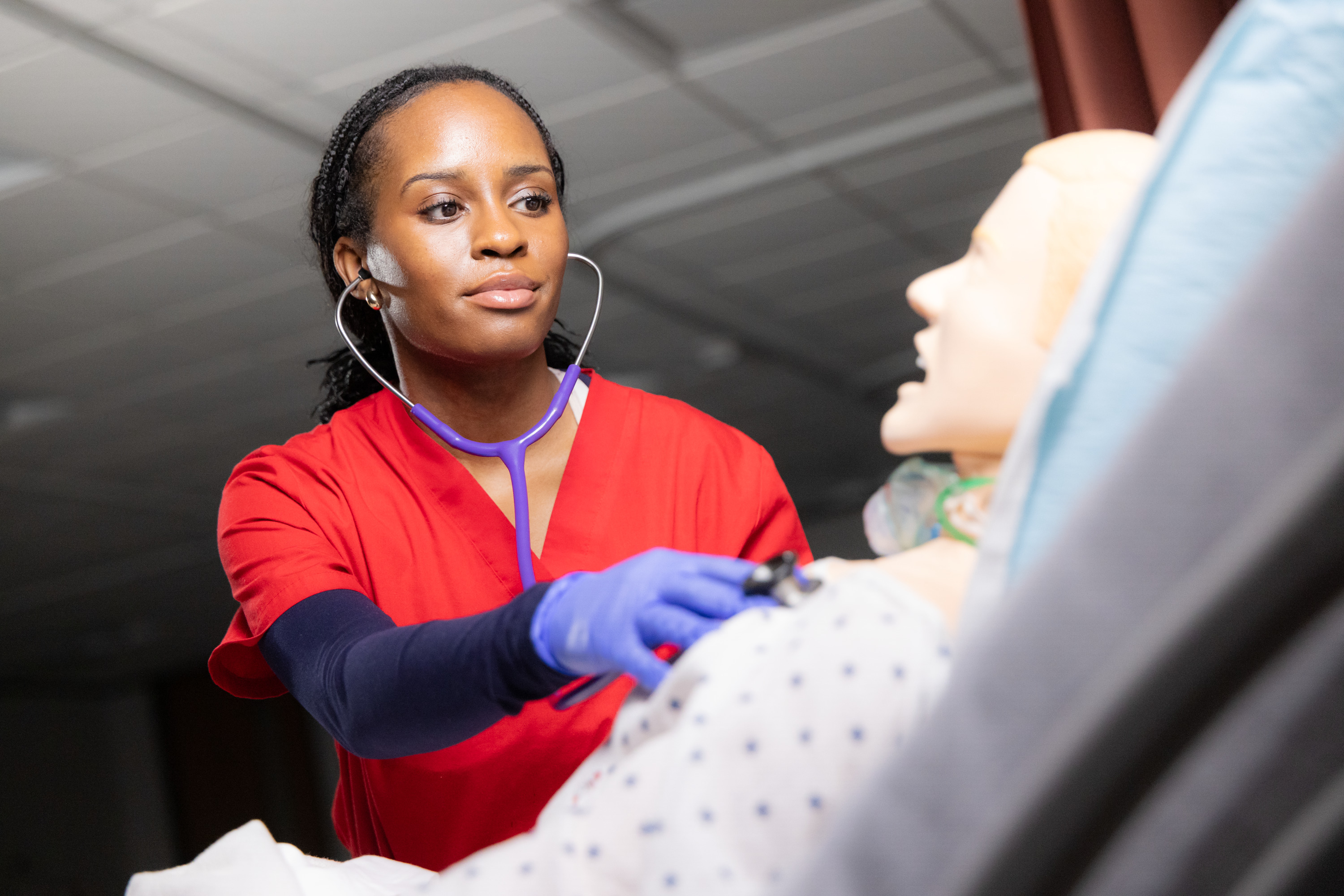 UST nursing student checking manikin with stethoscope