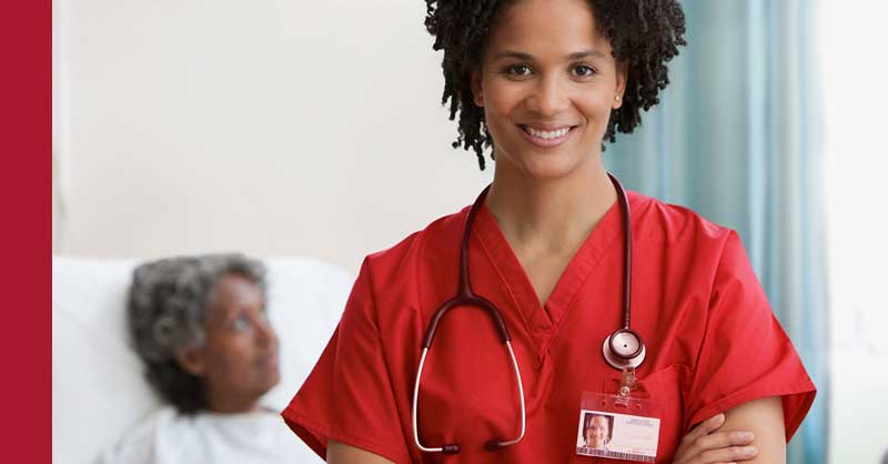 Nurse wearing red scrubs standing in patient room